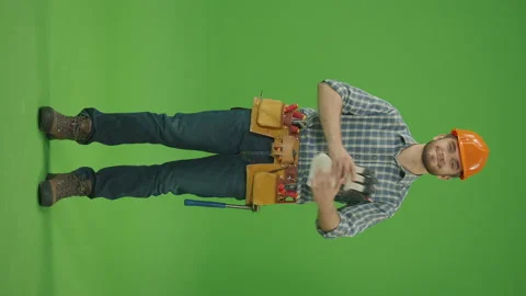 Green screen. Builder in a Hard Hat, Uses a Construction Tool. Vertical Footage Stock Footage 224783404