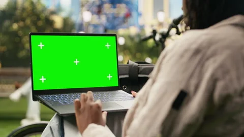 Green screen chroma key on laptop held against blurred city park Vídeo Stock 343501017