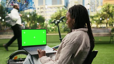 Green screen chroma key on laptop held against blurred city park Vídeo Stock 343507151