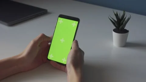 Green screen chroma key on smartphone on white table with small plant Stock Footage 169926463