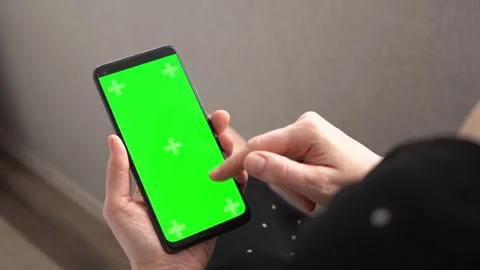 Green screen chroma key smartphone in vertical position close up in woman hands 库存影片 255890346