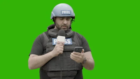 GREEN SCREEN CHROMA KEY War journalist wearing protective gear reporting live Stock Footage 154987846