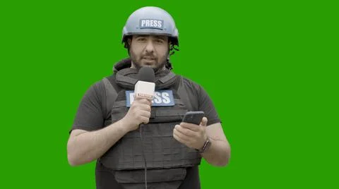 GREEN SCREEN CHROMA KEY War journalist wearing protective gear reporting live Stock Photos