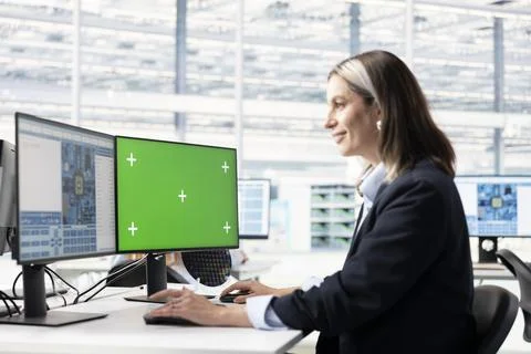 Green screen computer, designing complex PCB layout and female technician 写真素材