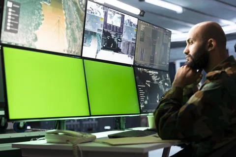Green screen computer monitors at military control workstation Foto stock