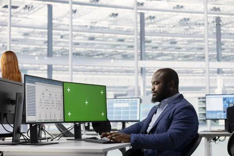 Green screen computer used by man evaluating PCB system architecture Stock Photos