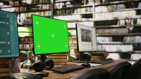 Green screen desktop with multiple monitors showing interfaces in library Stock Footage 337228728