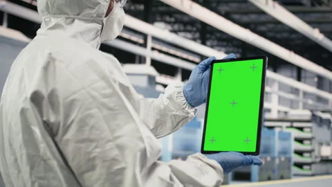 Green screen device used by engineer in semiconductor production plant floor Stock Footage 333391796