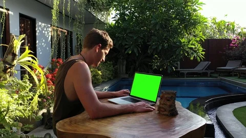 Green Screen Digital Nomad Reading Laptop by Beautiful Pool in Afternoon Stock Footage 119565558