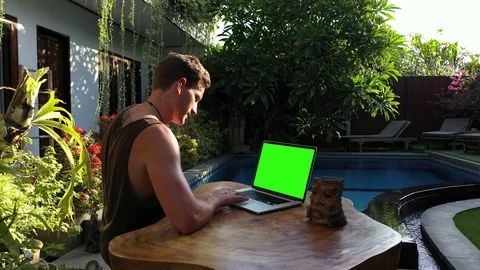 Green Screen Digital Nomad Reading and Scrolling on Laptop Beside Beautiful P Stock Footage 119566314