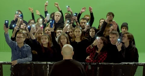 GREEN SCREEN Front view huge crowd of people with phones in hands at live Stock Footage 125634654
