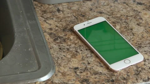 Green screen iphone sitting on a kitchen table during the day Видео 63056798