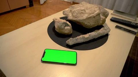 Green screen iPhone X on the table with some objects and Apple Tv Remote Video stock 127584772