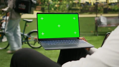 Green screen isolated mockup on laptop held against blurred city park Vídeo Stock 343506781