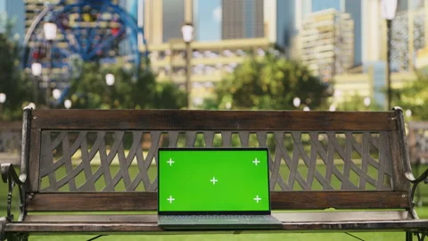 Green screen isolated mockup laptop on wooden bench placed in urban park Stock Footage 343507623
