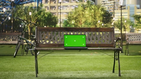 Green screen isolated mockup laptop on wooden bench placed in urban park Stock Footage 343507625
