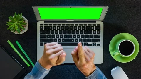 Green screen laptop computer on black wooden table with green colored stuff Stock Footage 77701468