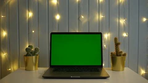 Green screen laptop computer on a homework desk in dark room with garland Video stock 148485497