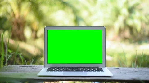 Green screen of laptop computer set on wood table in garden. Stock Footage 101718795