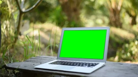 Green screen of laptop computer set on wood table in garden. Stock Footage 101719237