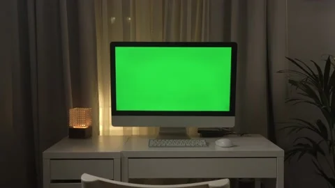 Green screen laptop computer sitting on a home work desk next to a desk lamp Stock Footage 142629206