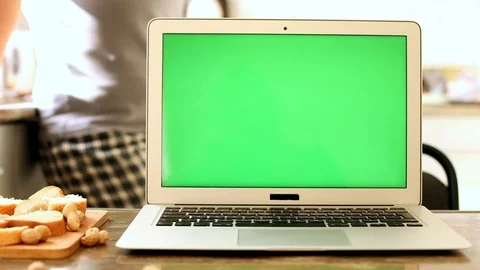 Green screen laptop computer in sunny kitchen interior with pregnant woman on ba Stockbeeldmateriaal 120174184