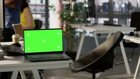 Green screen laptop on desk in workspace with admins in background Stock Footage 318159556