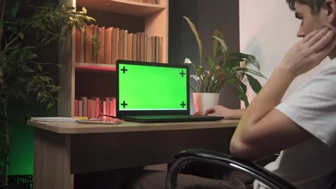 A green screen on a laptop, a guy working on a laptop in the office Stock Footage 264099275