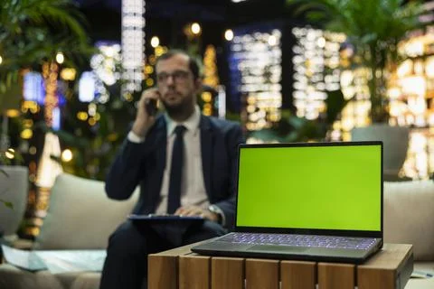 Green screen laptop mockup on table with CEO making phone call Foto stock