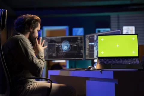 Green screen laptop next to programmer in home office staggered by sentient AI Foto stock