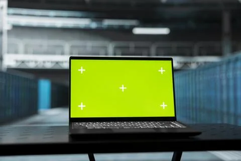 Green screen laptop overseeing data center equipment mainframes Stockfoto's