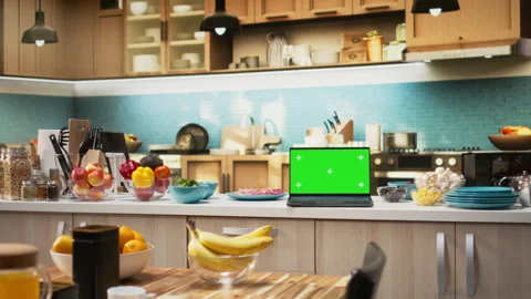 Green screen on a laptop placed on empty table in rustic kitchen space Video stock 326012926