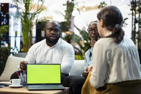 Green screen laptop on rooftop table used by team doing business meeting Stock Photos