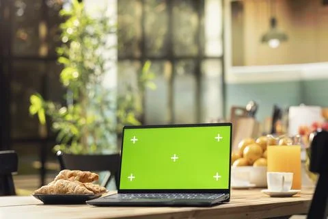 Green screen laptop, rustic kitchen interior, wooden breakfast table for coffee Stock Photos
