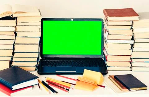 Green screen laptop, stack of books, notebook and pencils on white table, edu Stock Photos
