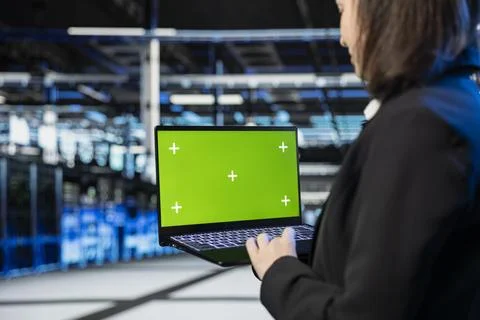 Green screen laptop used by admin in data center verifying firewall Stock Photos