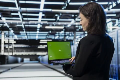 Green screen laptop used by developer in data center managing servers Stock Photos