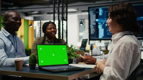 Green screen laptop used by programmers in startup office leveraging AI tech Stock Footage 323030322