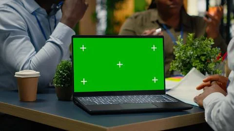 Green screen laptop used by programmers in startup office leveraging AI tech Stock Photos