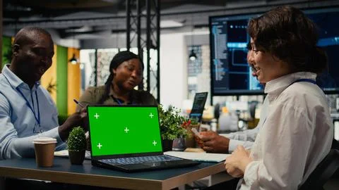 Green screen laptop used by programmers in startup office leveraging AI tech Foto stock