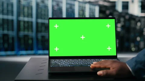 Green screen laptop used by server hub programmer to monitor rigs Stock Footage 330139990