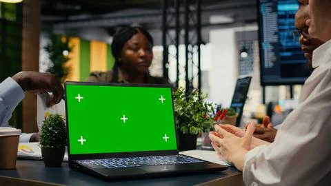 Green screen laptop used by tech startup office programmers doing meeting Stockfoto's