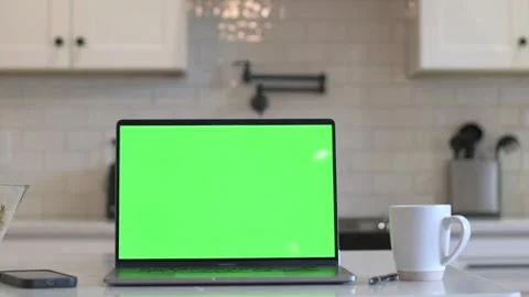 Green screen laptop on white table in kitchen setting Видео 320030414