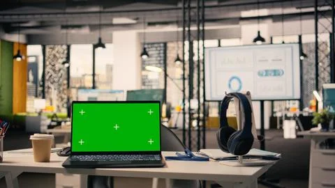 Green screen laptop at workstation in empty bright open office Stock Photos
