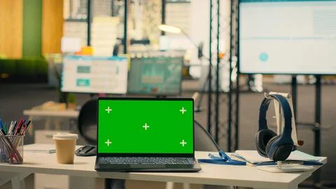 Green screen laptop at workstation in empty bright open office Stock Photos