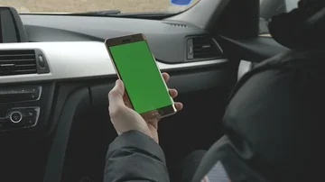 GREEN SCREEN man holding his smartphone in a car Stock Footage 85693231