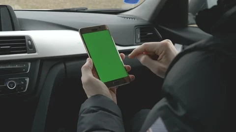 GREEN SCREEN man holding his smartphone in a car Stock Footage 85693549
