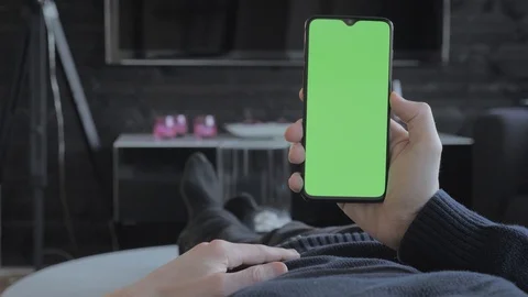 Green screen - Man at home lying on a couch looking at a smartphone. Stock Footage 106038363