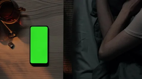 Green screen mobile lying on table while woman sleeping Stock Footage 162619601