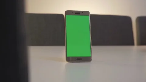 GREEN SCREEN mobile phone standing on the white table Stock Footage 83486830